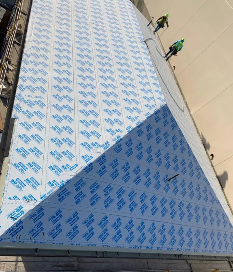 Professional roofers installing underlayment on a metal roof in Breitung